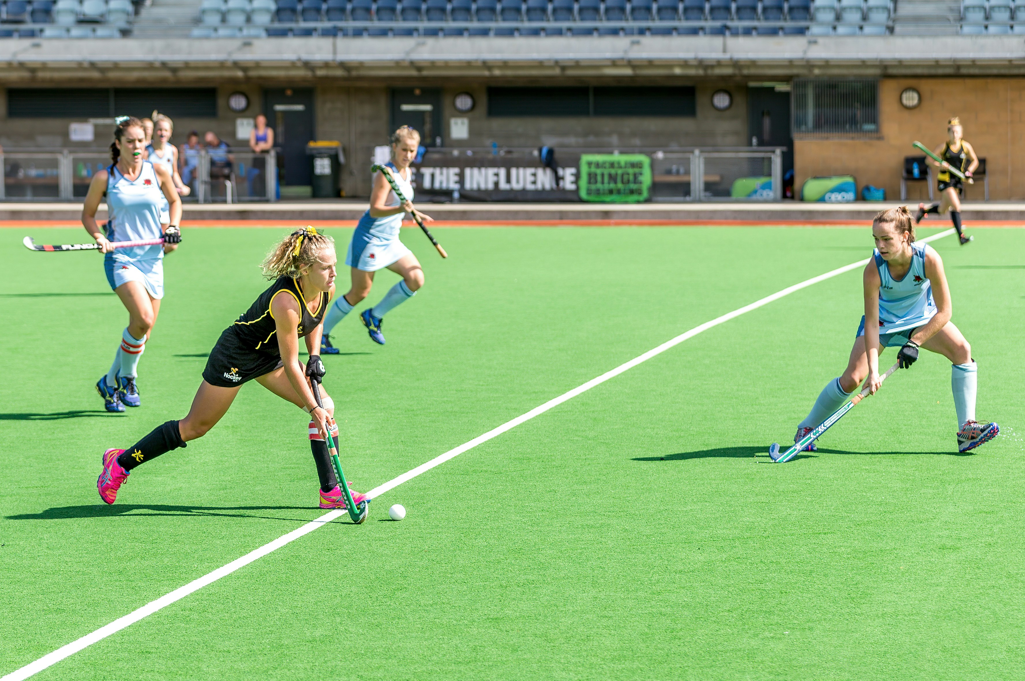 Field hockey players competing on green turf during a match