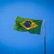 Brazilian national flag waving against bright blue sky