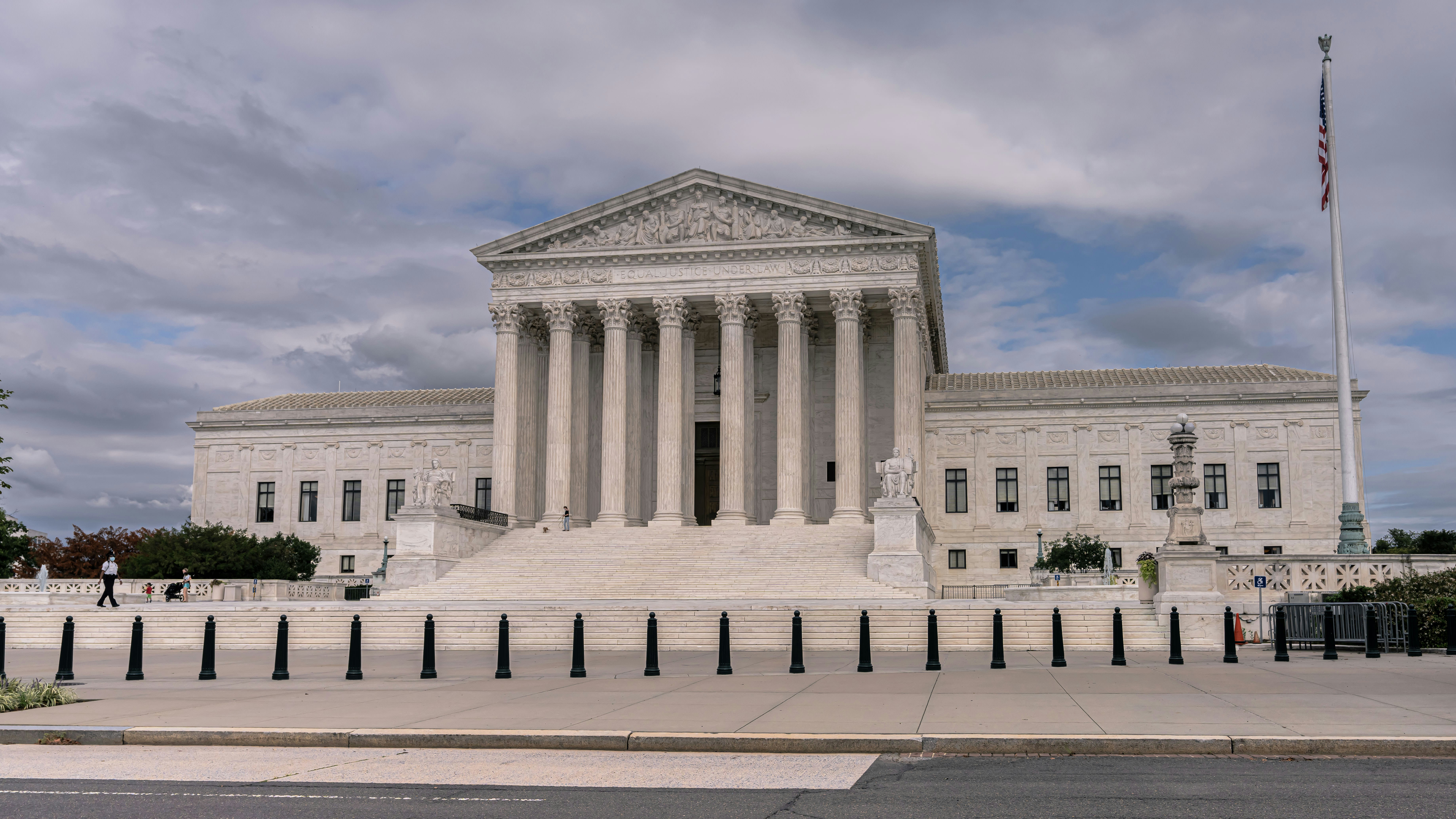 United States Supreme Court building with white marble facade and columns under cloudy sky
