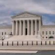 United States Supreme Court building with white marble facade and columns under cloudy sky
