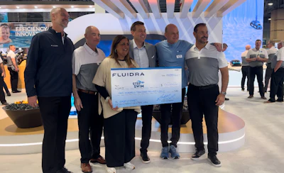 Fluidra team presenting oversized check at corporate event with multiple employees