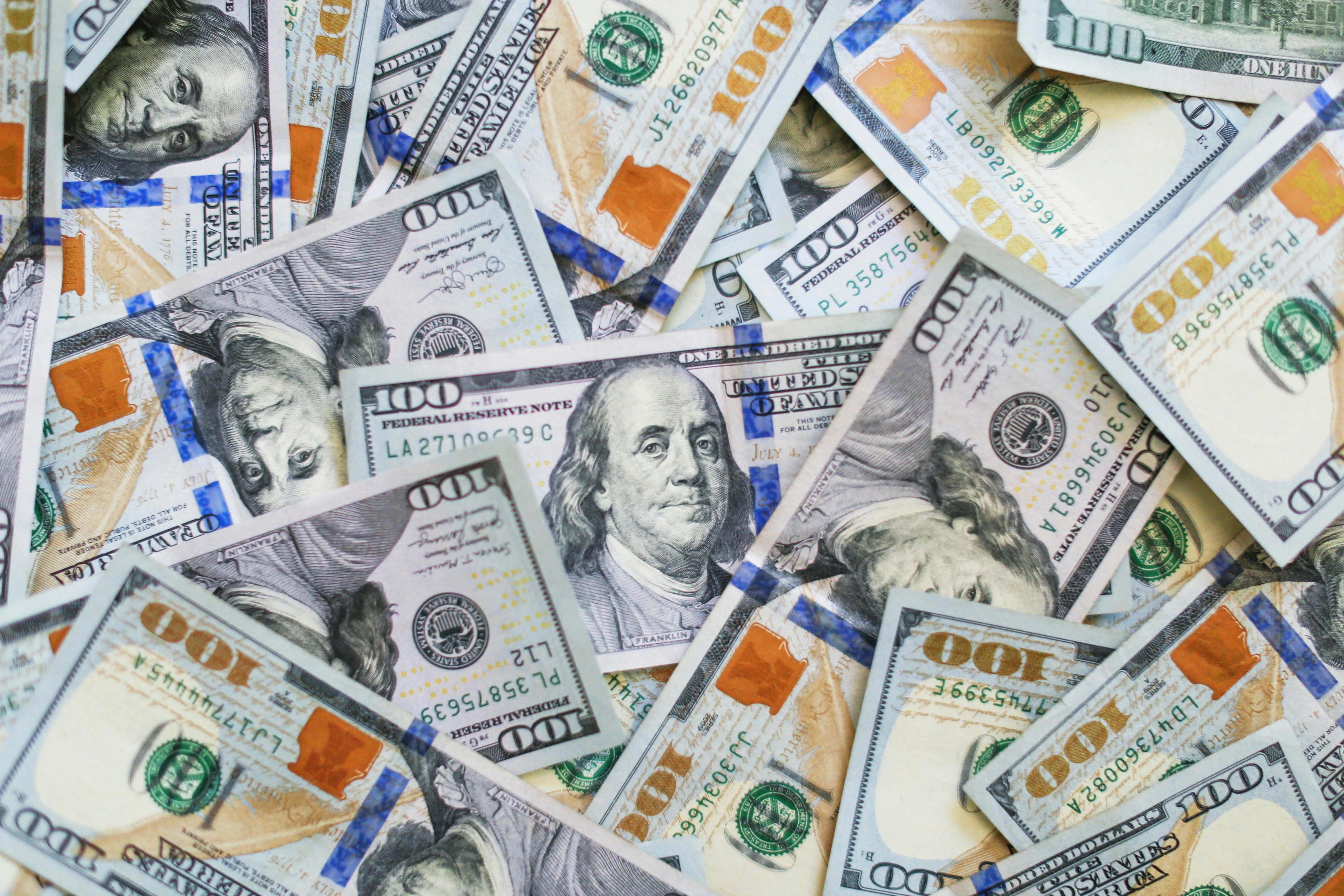 Scattered US $100 bills with Benjamin Franklin portrait