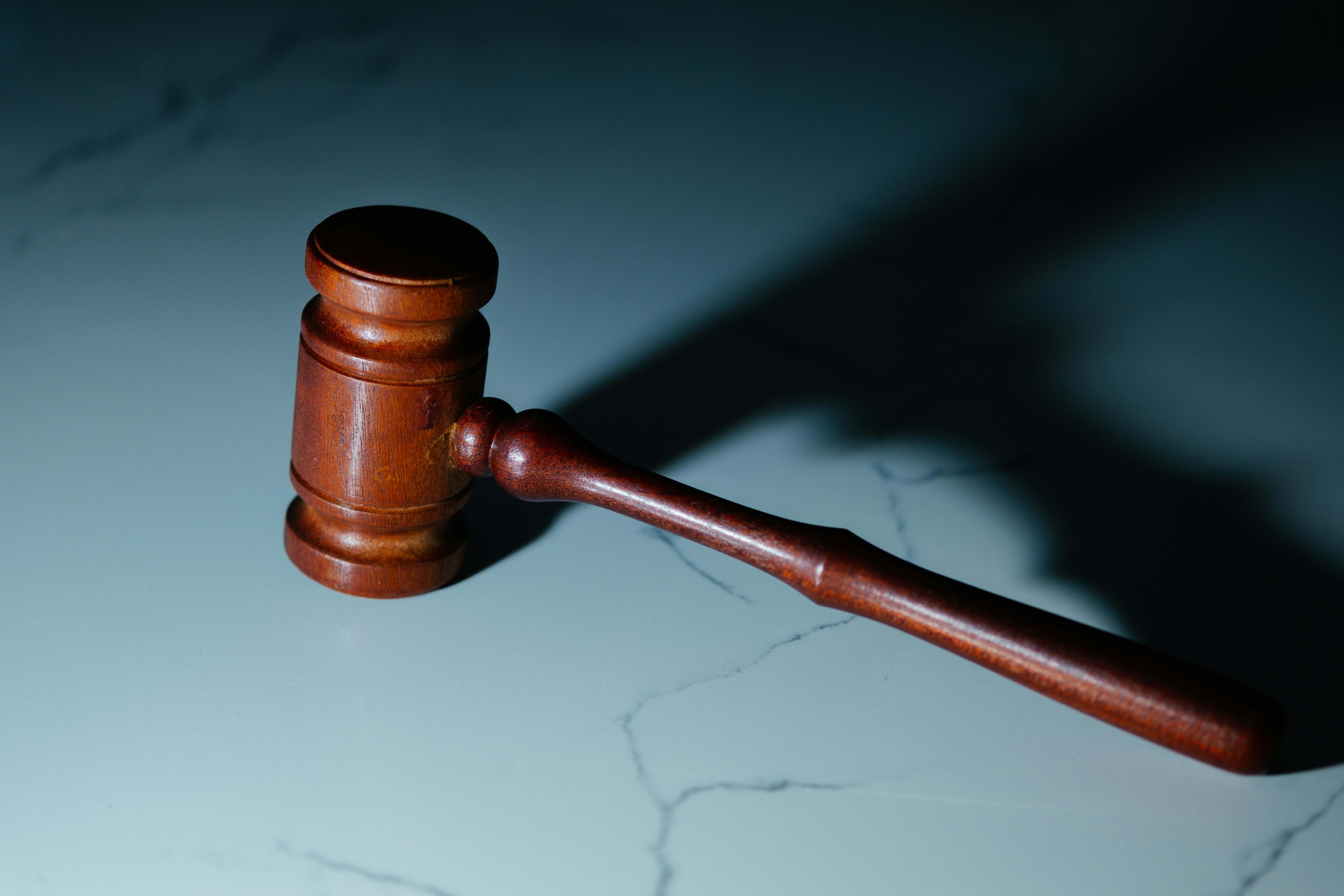 Wooden judge's gavel resting on marble surface