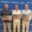 Three men holding American flag awards at Paddock Pool Equipment corporate event