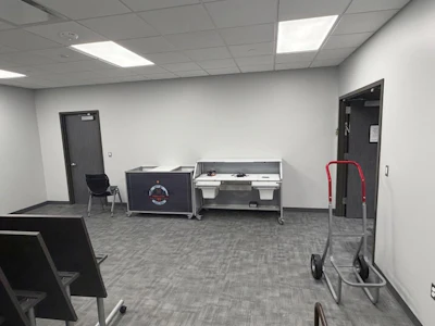The double door on the right goes to the meeting side and a door to the corridor is on the left. Doors are both on one side of room to maximize storage space, and the corridor door allows storage to be changed among storage rooms without disturbing the meeting room.