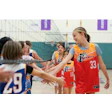 Youth volleyball team in iSports jerseys giving high-fives near volleyball net