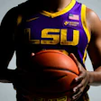 LSU basketball player in purple and gold jersey holding basketball
