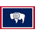 Wyoming state flag featuring white bison silhouette with circular seal on navy blue background, bordered in red and white