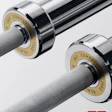 Professional IWF competition barbells with chrome sleeves and textured gray grips featuring gold competition collars