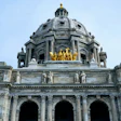 Minnesota State Capitol building dome with golden horses sculpture against blue sky