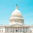 U.S. Capitol Building with white dome and neoclassical architecture against clear blue sky