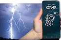 Smartphone displaying rainy weather forecast with 8°C temperature held against dramatic lightning storm background