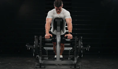 Man using leg press machine in gym with focused form during strength training workout