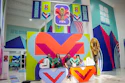 FIFA World Cup 2022 exhibition space with colorful geometric branding, large V-shaped logo installation, and visitors at interactive display area