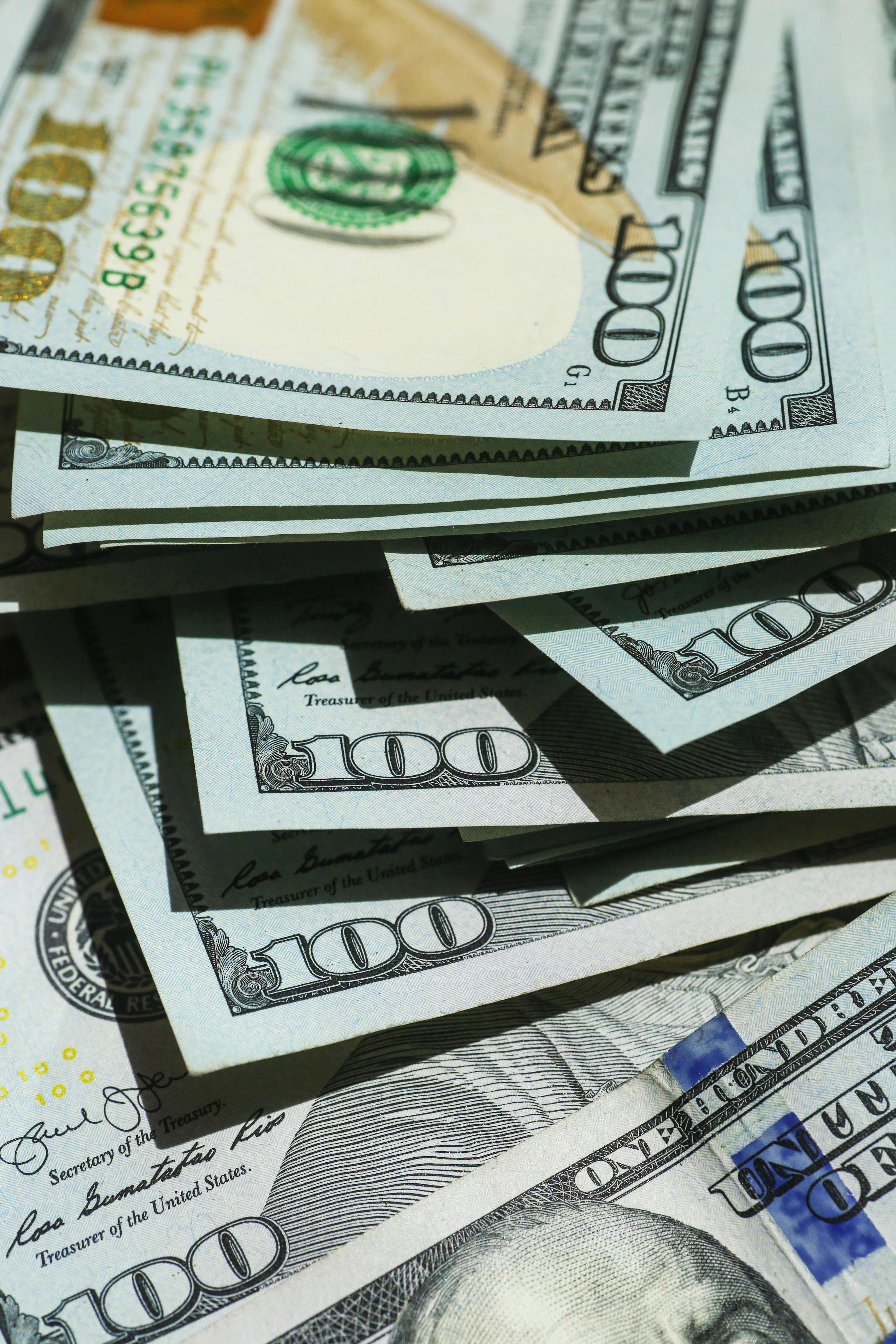 Stack of U.S. hundred dollar bills fanned out showing currency details and security features