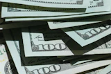 Stack of U.S. hundred dollar bills fanned out showing currency details and security features