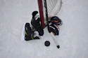 Overhead view of ice hockey players competing near the goal net with stick and puck on ice