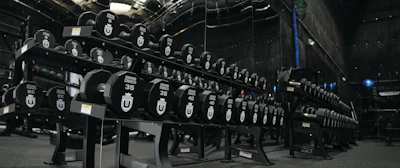 Black roller coaster cars with numbered shields lined up in an indoor amusement park facility