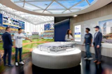 Modern stadium visitor center with curved architecture, baseball field views, and interactive displays featuring Tampa Bay Rays branding