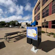 KU Recreation Services sign at outdoor basketball court with picnic table and brick building