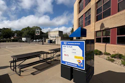 KU Recreation Services sign at outdoor basketball court with picnic table and brick building