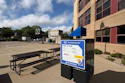 KU Recreation Services sign at outdoor basketball court with picnic table and brick building