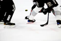 Ice hockey players in black uniforms with Toyota branding compete for the puck during a game.