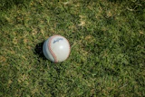 White baseball with red stitching on grass field