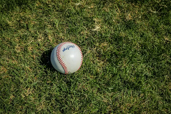 White baseball with red stitching on grass field