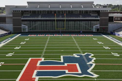University of Illinois Illini logo on football field with stadium seating in background
