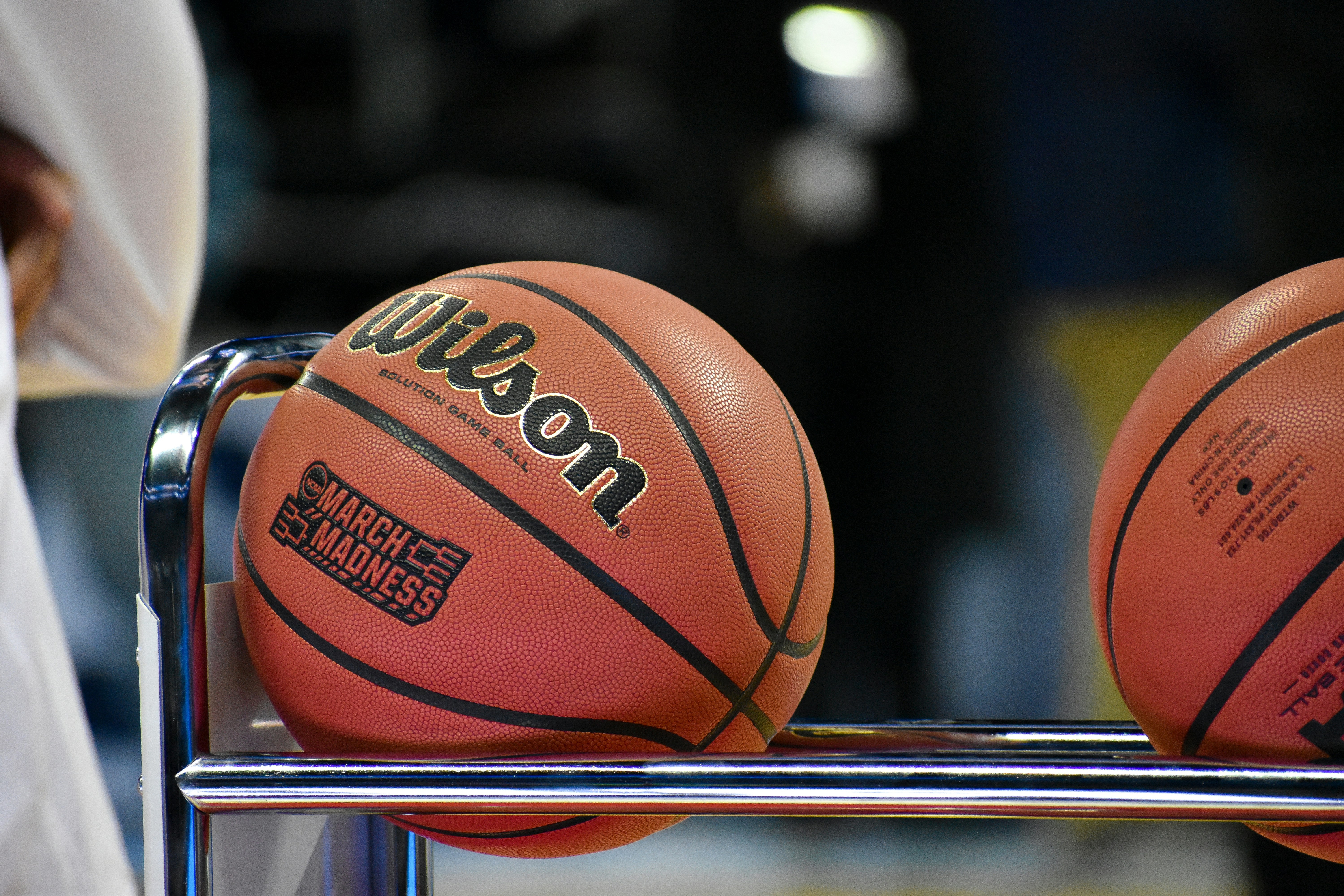 Wilson basketballs with March Madness branding displayed on a rack