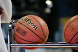 Wilson basketballs with March Madness branding displayed on a rack