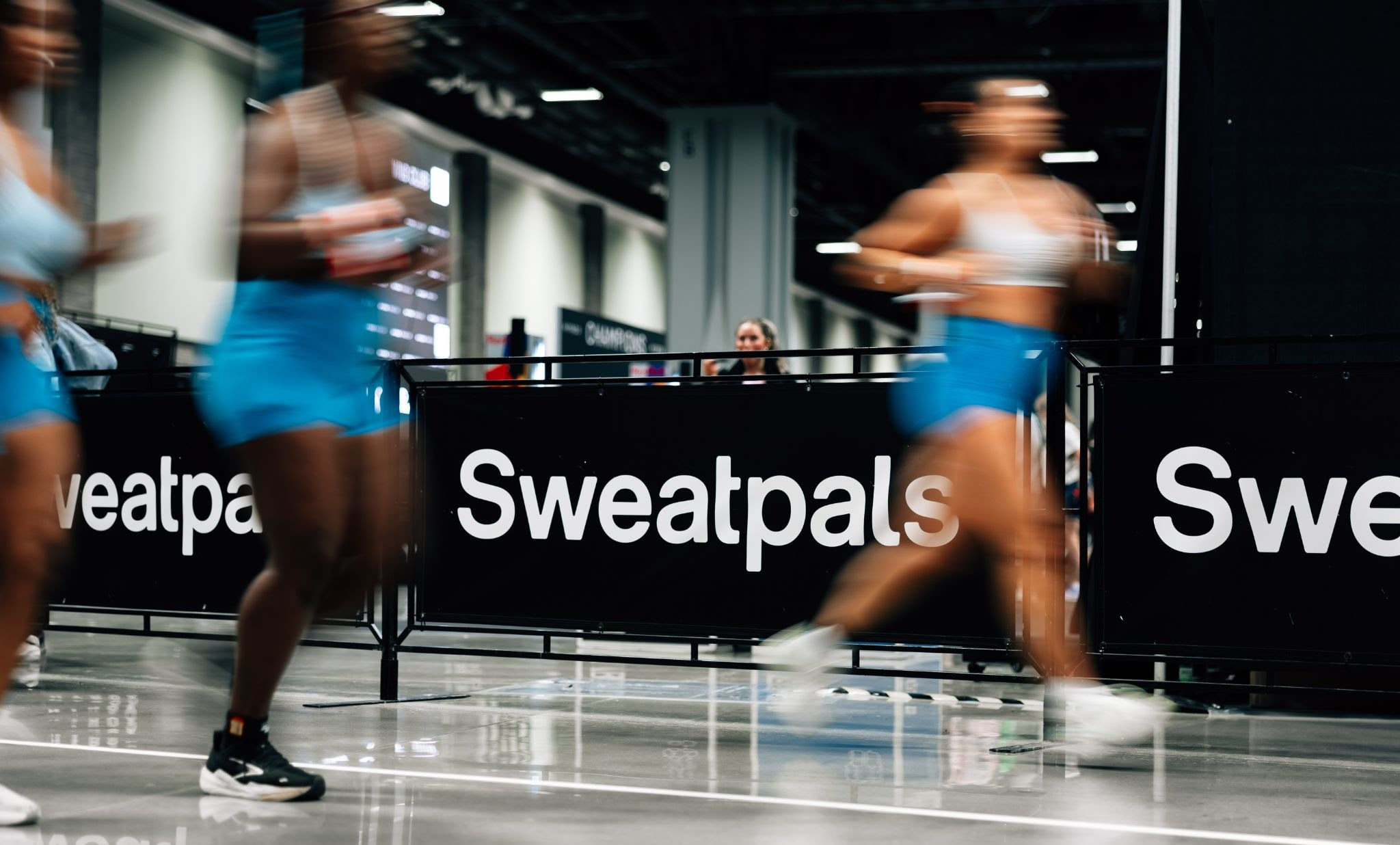 Athletes training indoors at Sweatpals fitness facility with motion blur effect