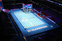 Olympic swimming competition pool with blue deck and lane dividers in an indoor stadium venue